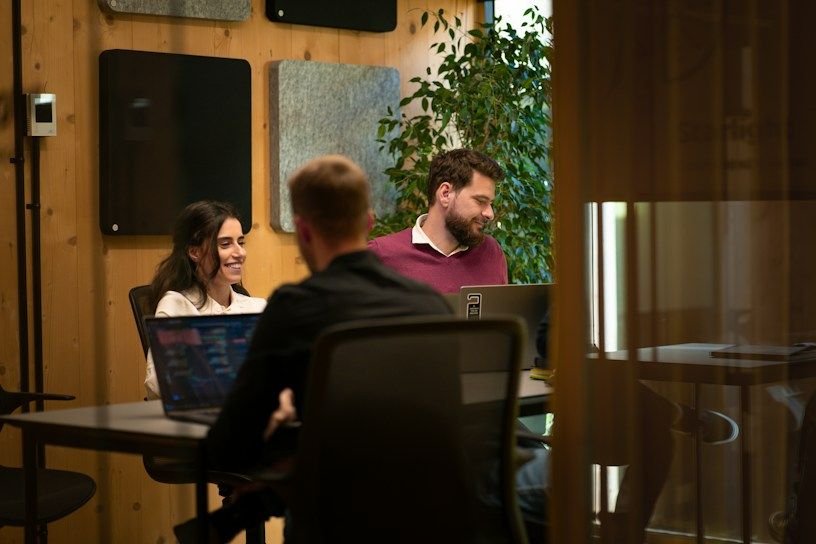 Colleagues meeting around a table in a wood panelled office